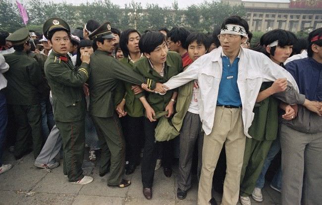 Students and police link area to keep crowd of people, many of the relatives of strikers, from Tiananmen Square, where students have been on hunger strike since Saturday, Thursday, May 18, 1989, Beijing, China.