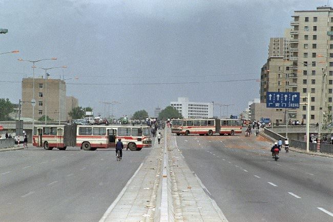 A convey of soldiers from the Peoples’ Liberation Army is completely engulfed by demonstrators who stopped the Tiananmen Square bound troops by blocking the road with the bus in the foreground, May 21, 1989, Beijing, China.