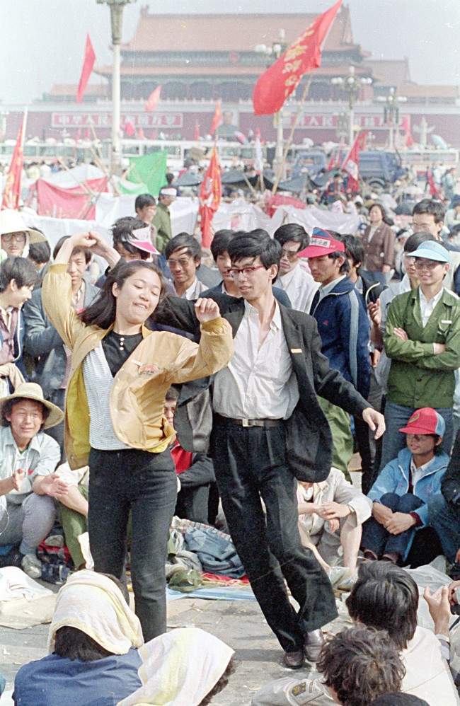 A young unidentified couple, two out of thousands of university students who are holding Tiananmen Square occupied for nine days, pass the time with a lively dance on Monday morning, May 22, 1989 in Beijing, China.