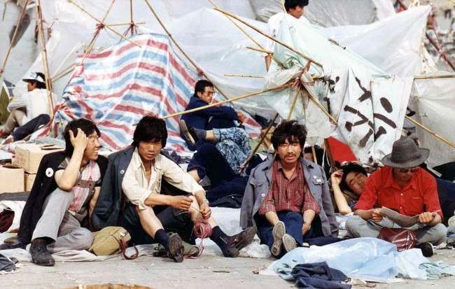 A group of students rest before their tattered tents in Tiananmen Square, Beijing, on May 27, 1989, where thousands of students continue their sit-in protest to press the government for political reforms.