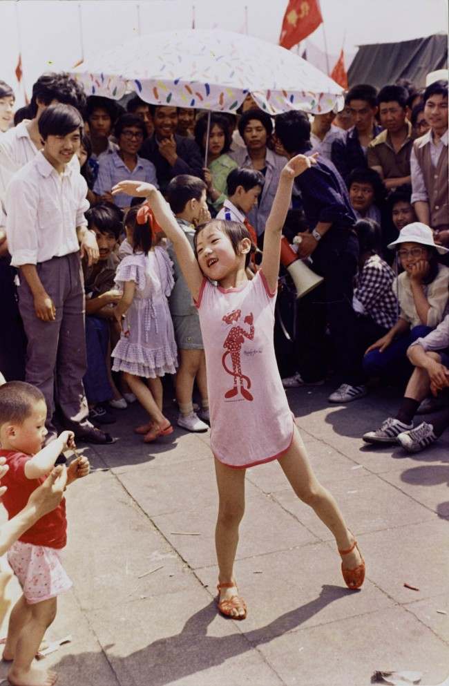 A young Chinese girl dances on Tiananmen Square about June 1, 1989, as pro-democracy protesters continued to occupy the square. Hundreds were killed a few days later in violent clashes between the demonstrators and government troops.