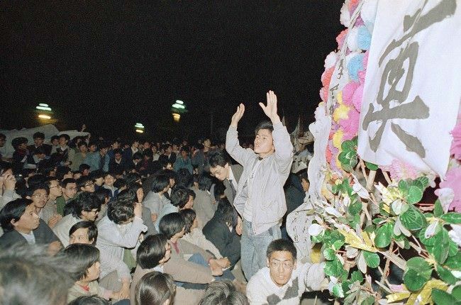 A student leader tries in vain to settle down a crowd of Beijing University students who converged on the Chinese Communist Party headquarters at Zhongnanhai early on Wednesday, April 19, 1989 in Beijing after demonstrating in Tiananmen Square all day on Tuesday. The students later tried to storm the gate, but were fought by Chinese security.