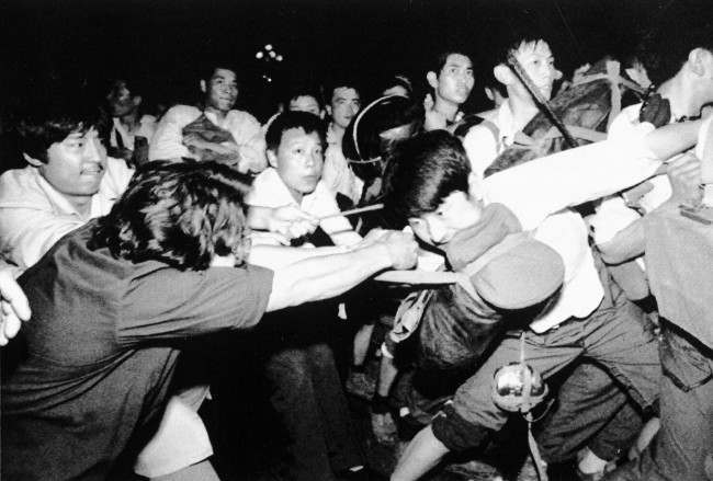 A man tries to pull a Chinese soldier away from his comrades as thousands of Beijing’s citizens turned out to block thousands of troops on their way towards Tiananmen Square early Saturday morning, June 3, 1989.