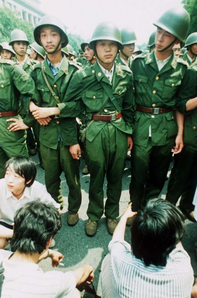 PLA soldiers locked in arms try to march past a human blockade of students outside of the Great Hall of People in this June 3, 1989 photo. Soldiers were reported to resort to teargas and amunitions.