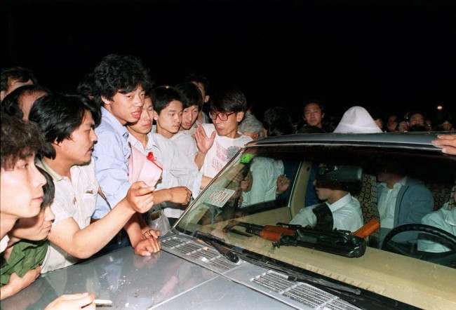 Beijing residents ask soldiers what they were going to do with the machine gun on their dashboard as they surround and stop a carload of chinese soldiers on their way towards to Tiananmen Square in this June 3, 1989 photo.