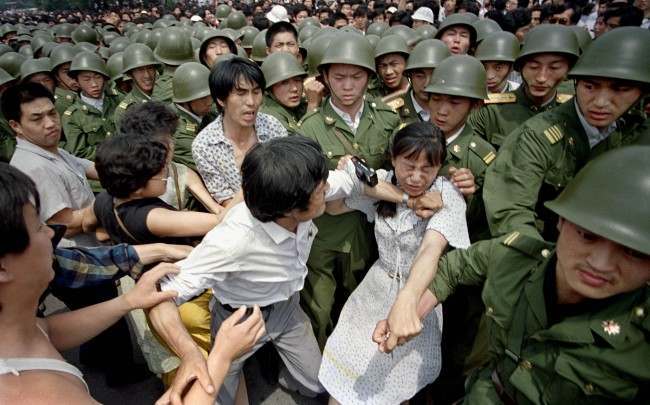 A young woman is caught between civilians and Chinese soldiers, who were trying to remove her from an assembly near the Great Hall of the People in Beijing, June 3, 1989. Pro-democracy protesters had been occupying Tiananmen Square for weeks.