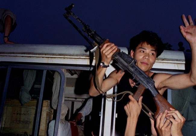 An anti-government protester in Beijing holds a rifle in a bus window, June 3, 1989. Pro-democracy protesters had been occupying Tiananmen Square for weeks; hundreds died that night and the following morning in clashes with Chinese troops.