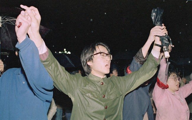 University students hold hands as they sing the Chinese National Anthem during a protest, April 21, 1989 in Beijing’s Tiananmen Square.