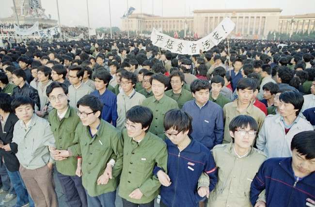 Chinese students link arms in solidarity at dawn on Saturday, April 22, 1989 in Beijing’s Tiananmen Square after spending the night there in order to be on hand for memorial services for the late purged party chief Hu Yaobang.