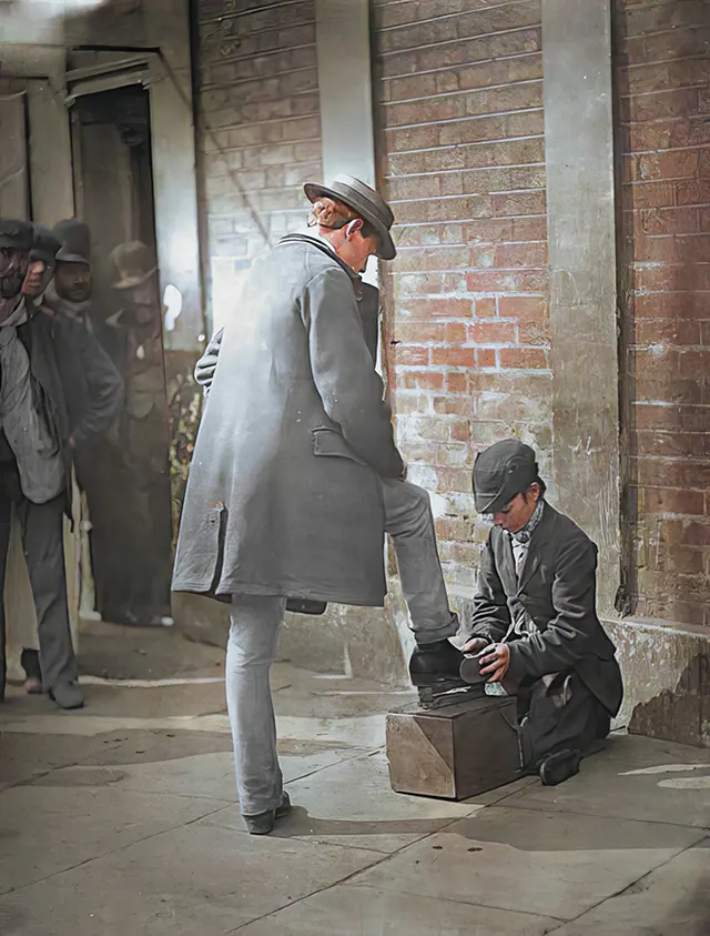 A young shoe-shiner at work, 1890s.