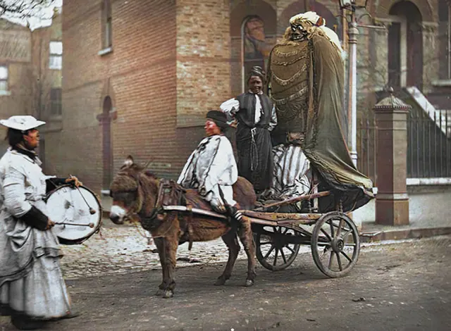 Effigies are pulled through the street in anticipation of Guy Fawkes Night, 1890s.