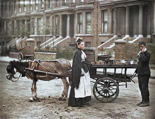 A fruit vendor with a cart pulled by a donkey, 1890s.