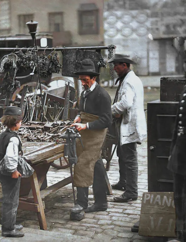 A locksmith at work at his street stall, 1890s.