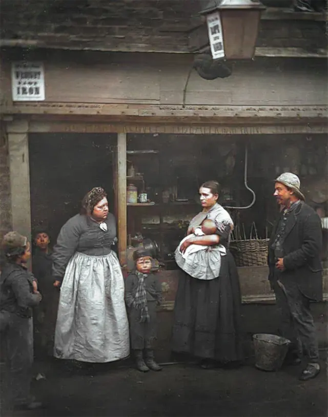 People gather outside of a rag shop in Lambeth, 1890s.