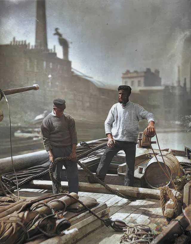 Two men working on a barge on the River Thames, 1877.