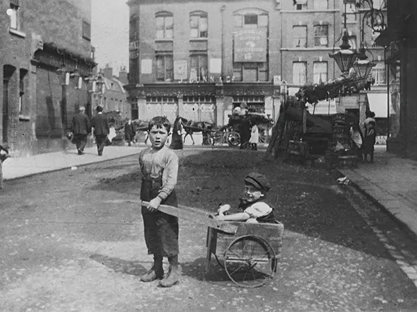 Two Jewish children play on an East End street. 1900s.