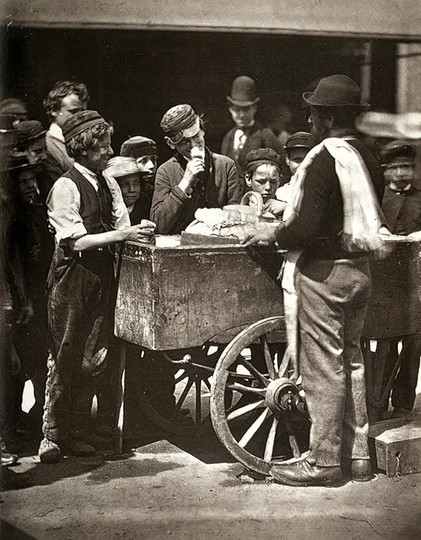 An Italian ice man selling ices to children and other slum residents. 1877.