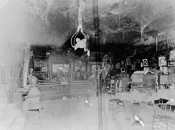 The interior of Cobweb Palace, known for its eccentric owner Abe Warner, who allowed spiders to spin countless webs throughout the establishment.