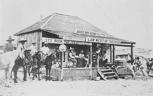 Saloons, among the largest and newest buildings in Wild West towns, often served multiple purposes. The Judge Roy Bean Saloon, depicted in 1900, doubled as a “Hall of Justice,” where men gathered to witness the trial of a horse thief.