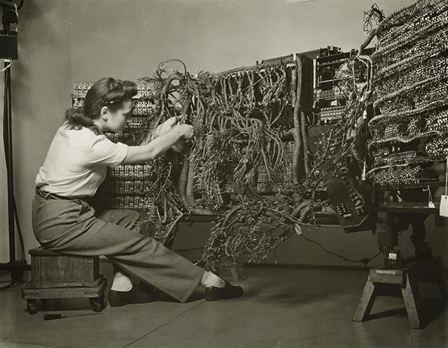 Woman wiring an early IBM computer.