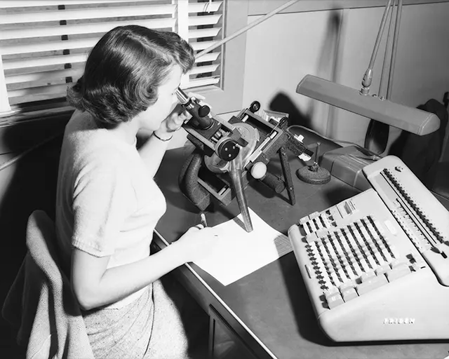 NACA computer working with microscope and calculator, 1954.