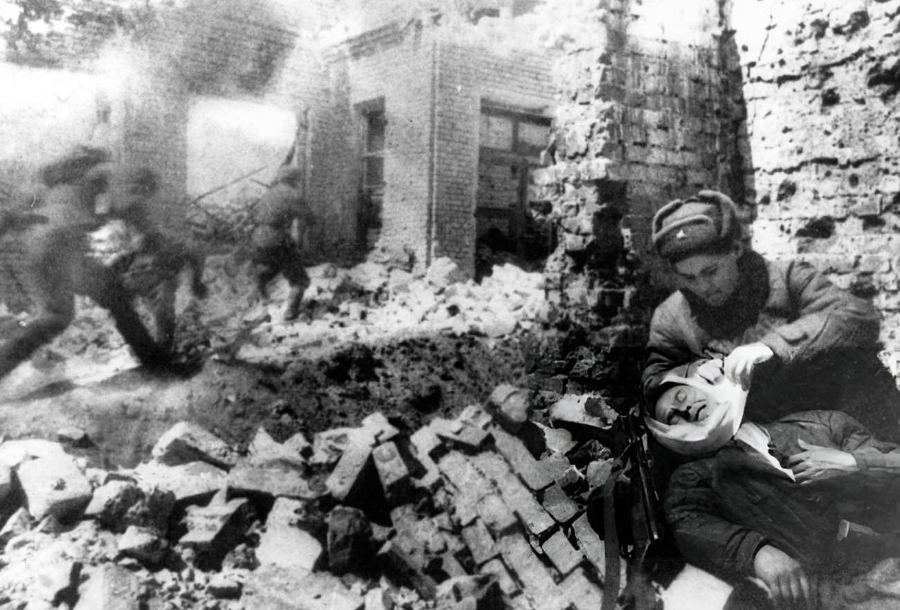 Nurse bandaging a wounded soldier during street fighting in Stalingrad, 1942.