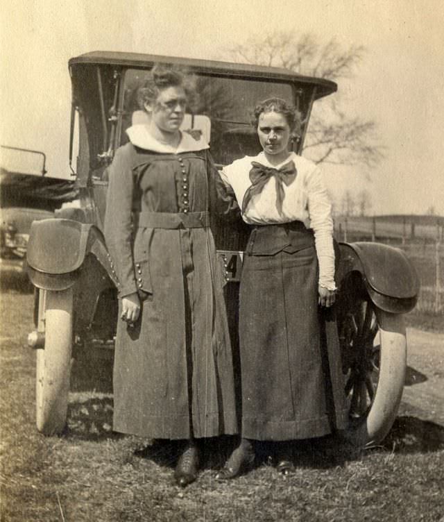 Mother and daughter pose in front of their automobile