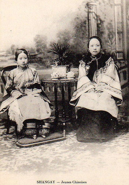 Judging by their fancy outfits, these young ladies were likely of noble birth. This status is reinforced by the tiny shoes peeping out from beneath the dress worn by the girl on the left, evidence of foot binding.