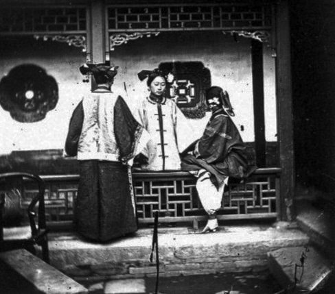 In this 1868 photograph, three Chinese ladies gather for a chat in what looks like a courtyard. Chinese women’s clothing was considered unshapely and demure by Western standards, even at that time.