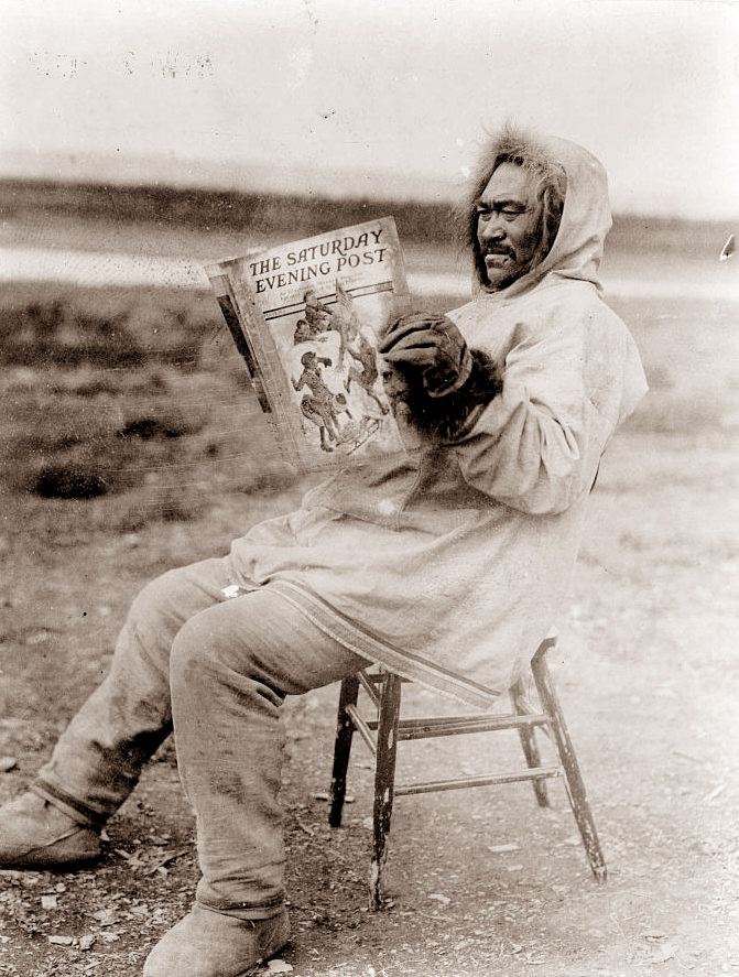 Eskimo Man reading a copy of the Saturday Evening Post, 1913