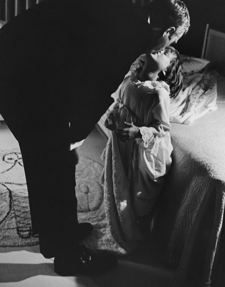 Steve McQueen kisses his daughter Terry goodnight, 1963.