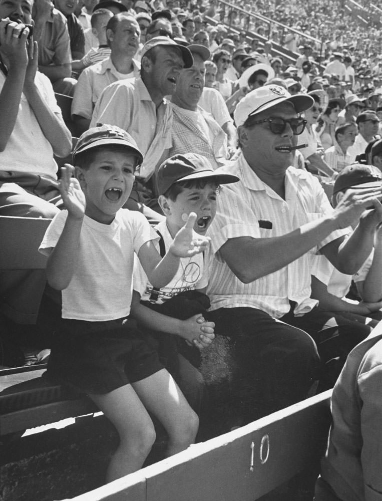 Desi Arnaz cheers on the Dodgers while sitting next to his young son, Desi Jr., and child actor Richard Keith who played "Little Ricky" on "I Love Lucy", 1958.