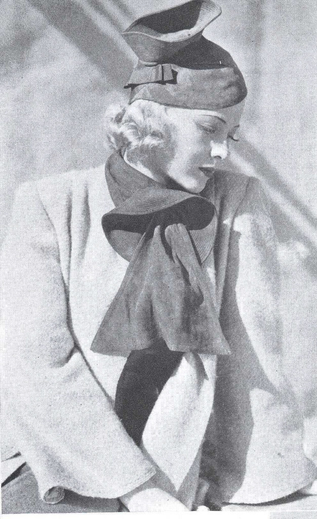 Mary Carlisle in a hat and scarf of rust suède, 1937