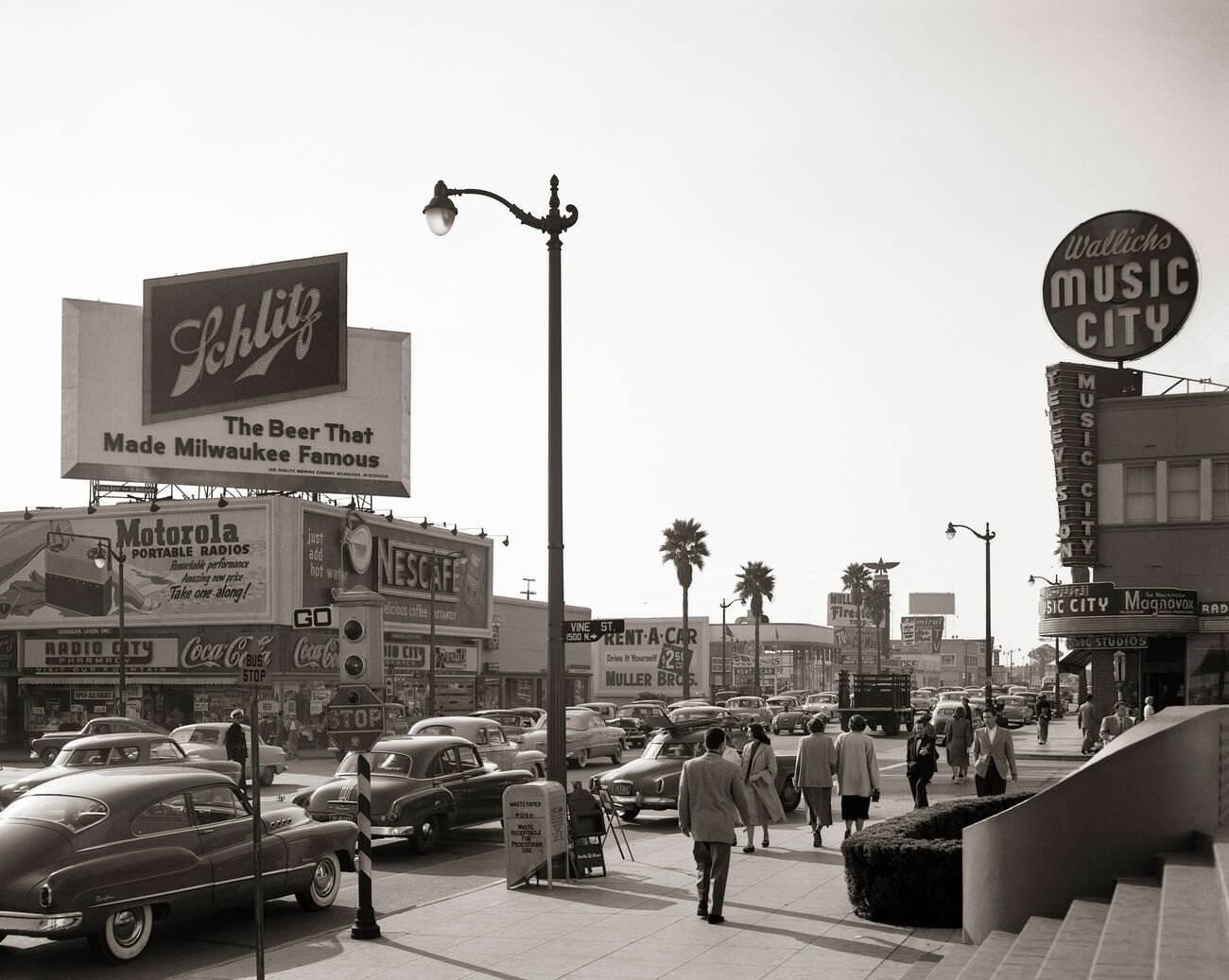 Busy street scene on Sunset Boulevard and Vine Street in Hollywood, California, 1950s.