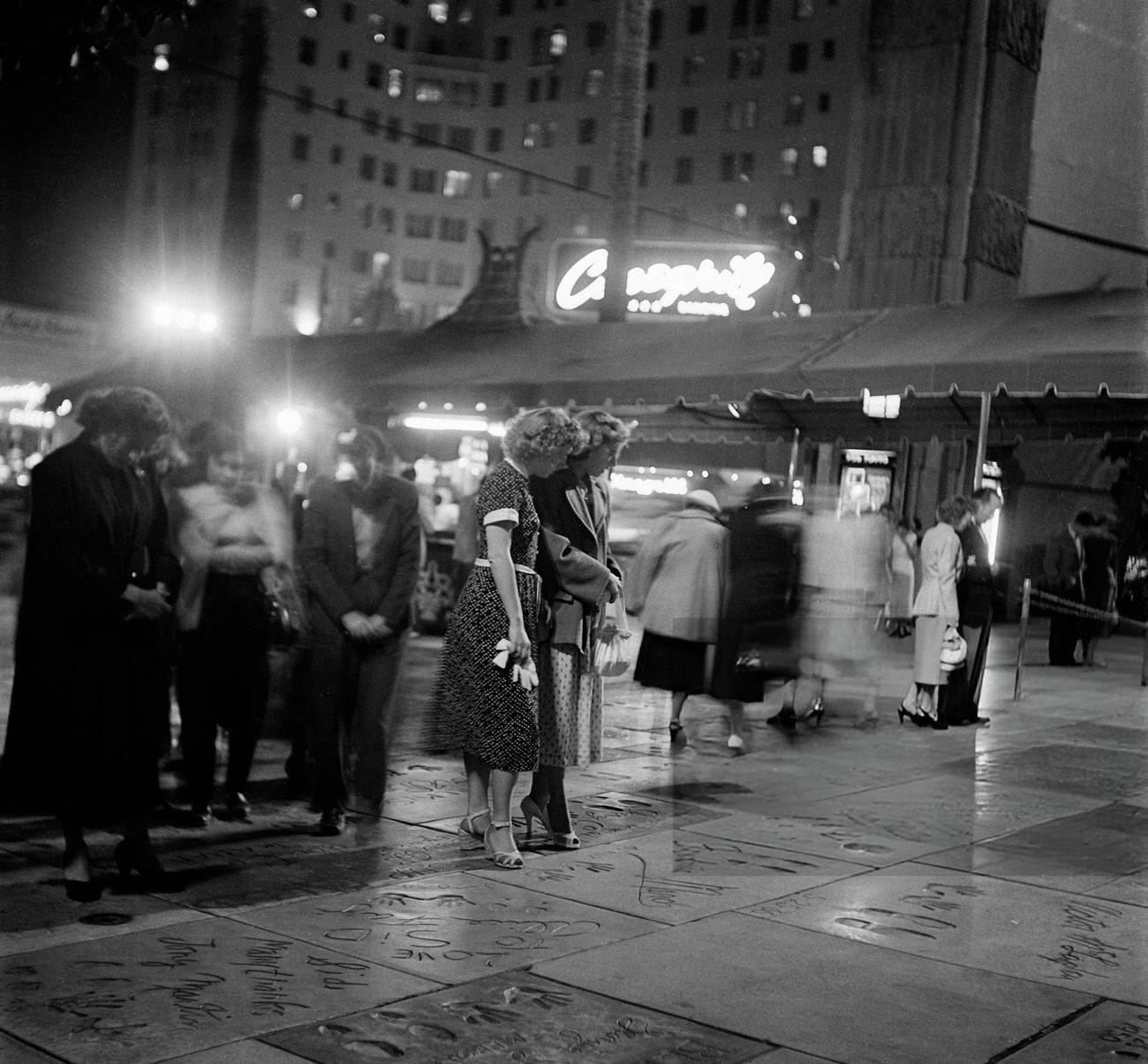 Tourists visiting the footprints at Mann's Chinese Theatre on Hollywood Boulevard in Hollywood, California, 1951.