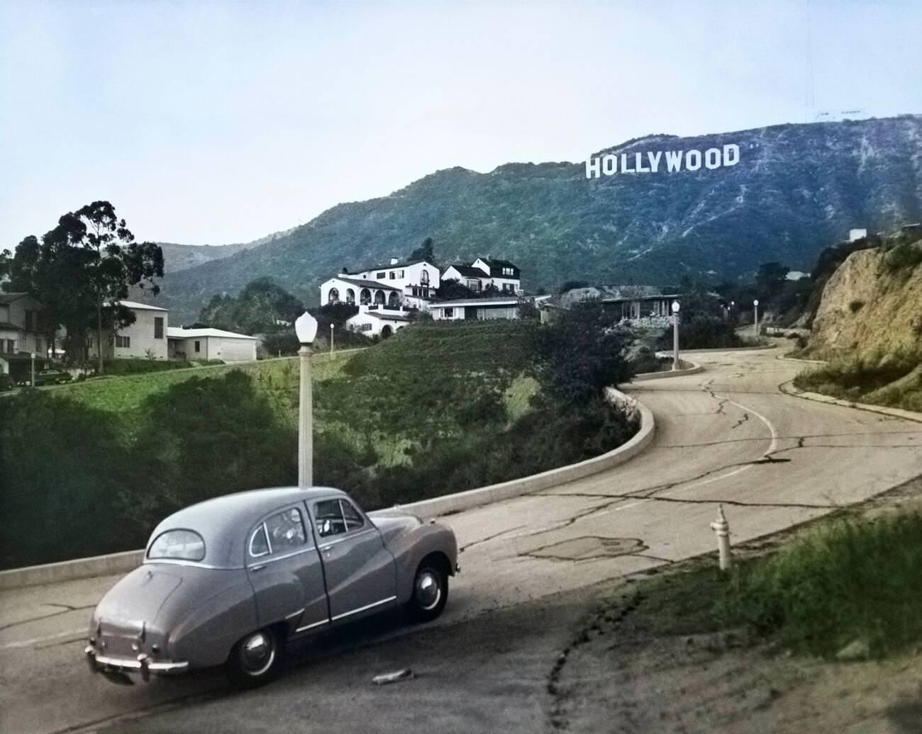 Austin car driving up a road in the Hollywood Hills, 1950s.