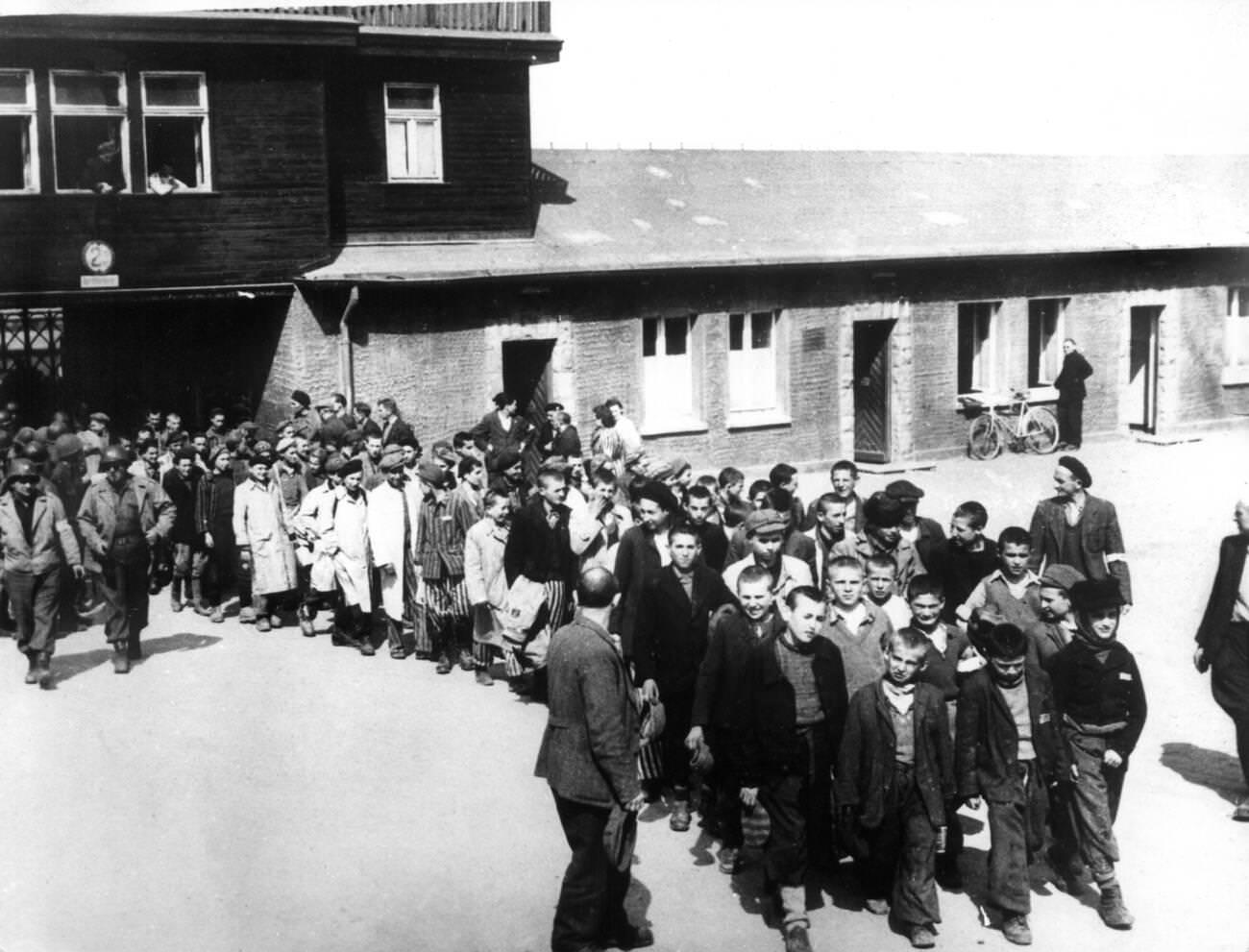 Children and youths are being led in columns by soldiers of the 3rd US Army to a hospital sick bay after the liberation of the Buchenwald concentration camp, 1945.