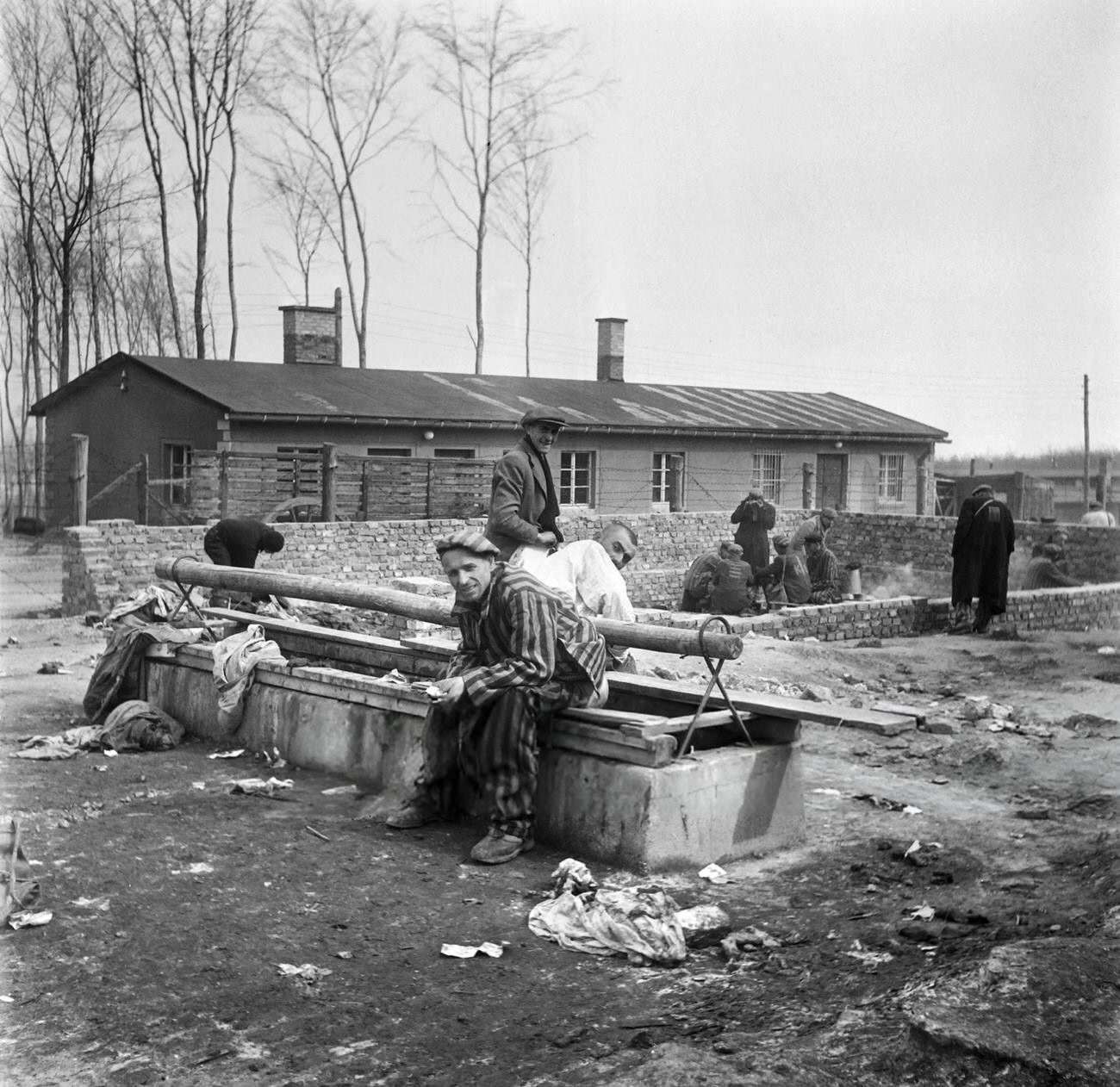 Survivors of the Buchenwald Nazi concentration camp sit on a latrine, 1945.