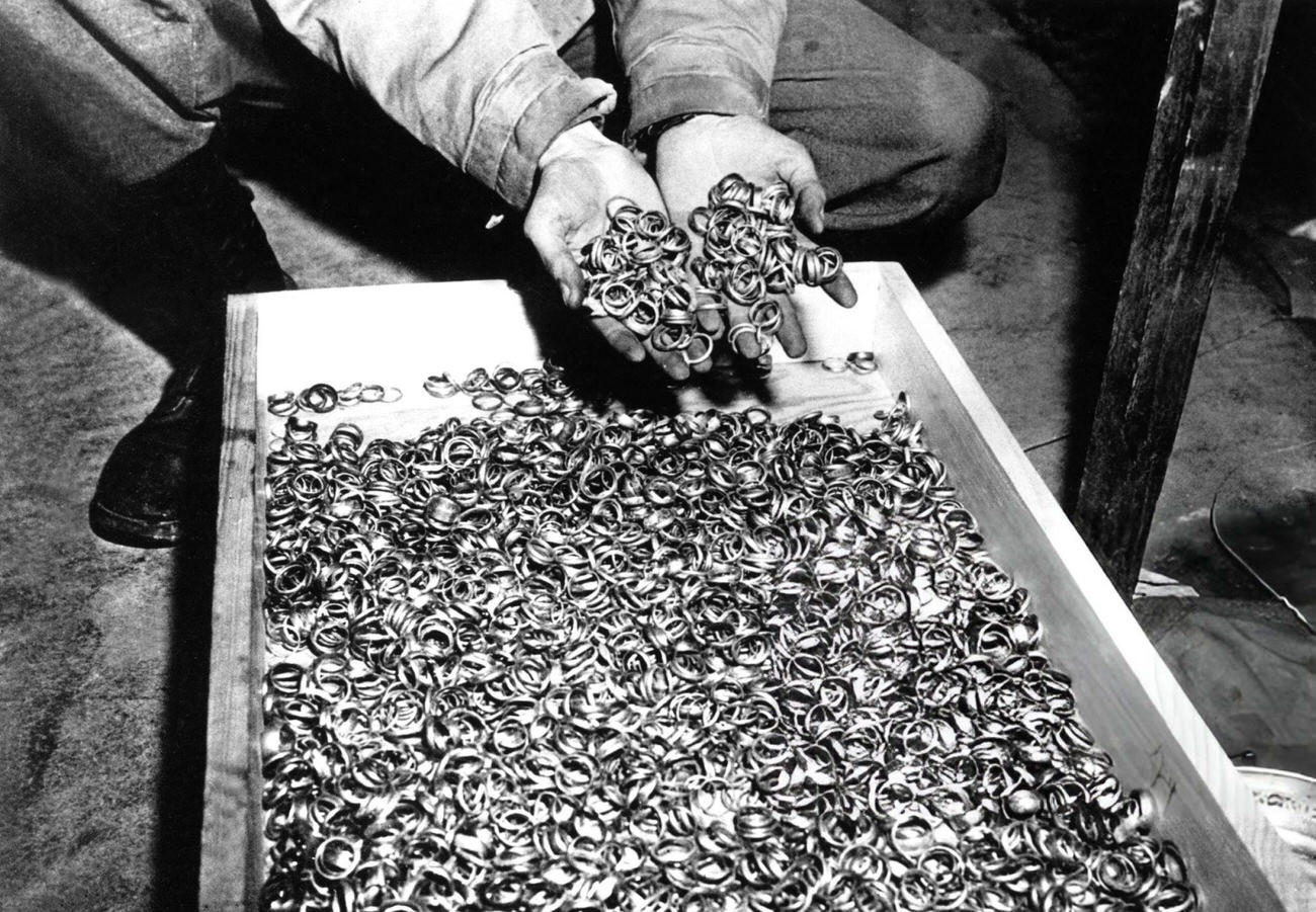 An American Soldier Discovering a Box Full of Rings of Deportees Who Were Taken Their Jewels on Their Arrival to the Camp, 1945.