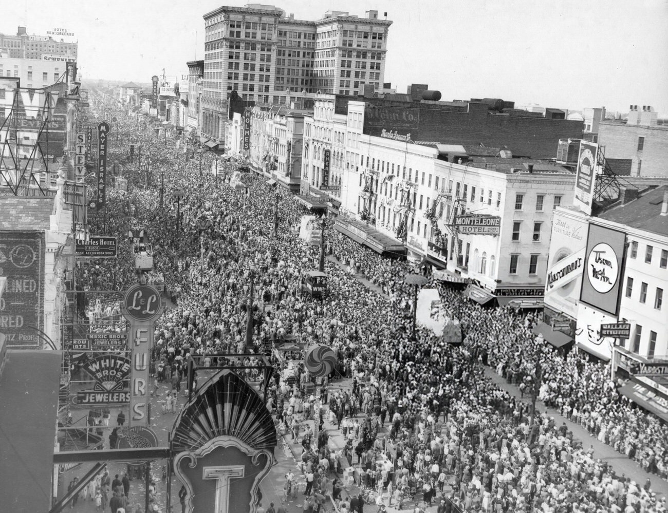 Canal Street View with Crowds of People Watching Floats of the Mardi Gras Parade Pass By, New Orleans, 1950.