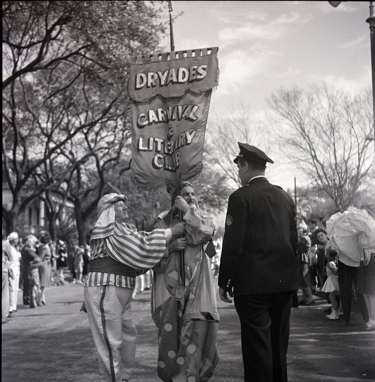 Two Costumed Men with the Dryades Carnival & Literary Club Parade, Talk to a Police Officer During Mardi Gras, 1950s.