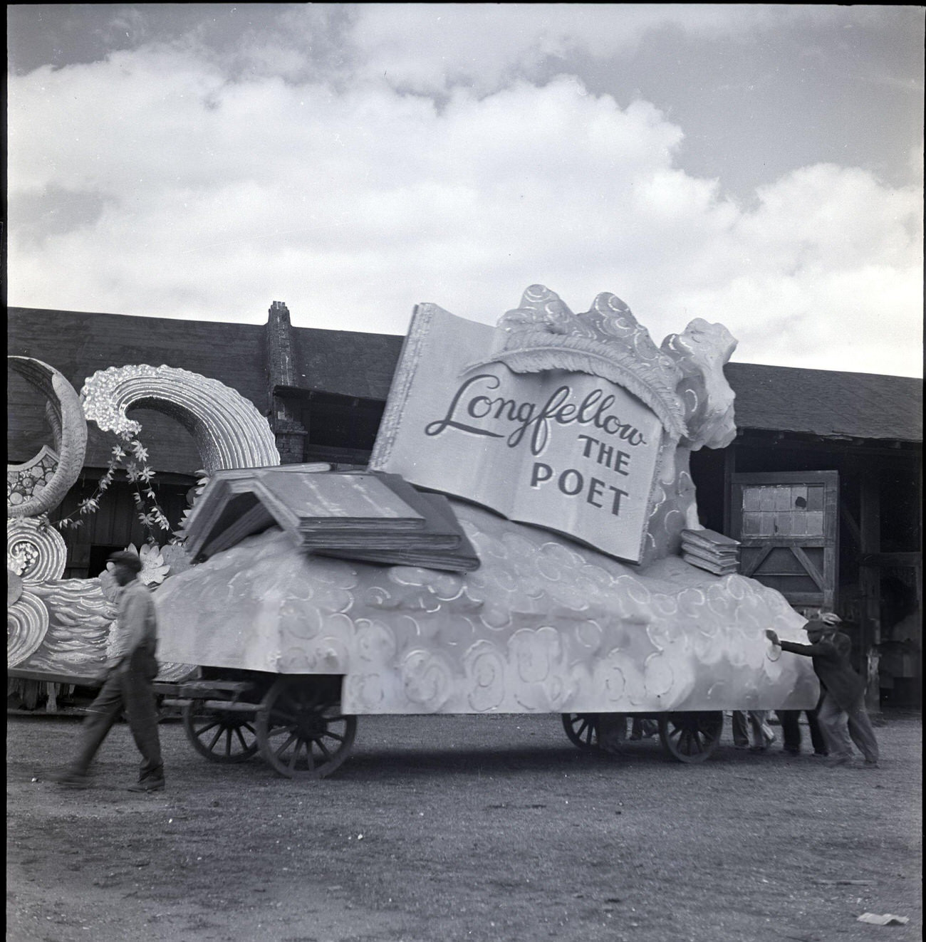 Men Push a Mardi Gras Parade Float, Dedicated to Longfellow, Out of a Warehouse, 1950s.