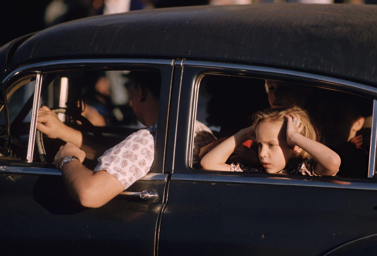 A Little Girl Watches the Mardi Gras Celebrations in New Orleans From the Back Seat of a Car, 1961.