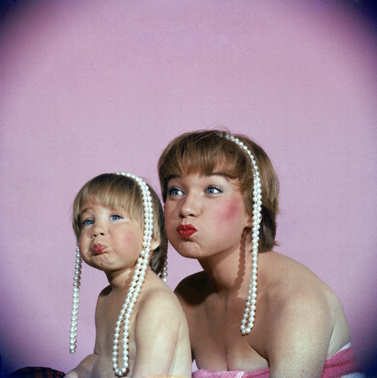 Shirley MacLaine and her daughter, Sachi Parker, with pearl necklaces, 1959.