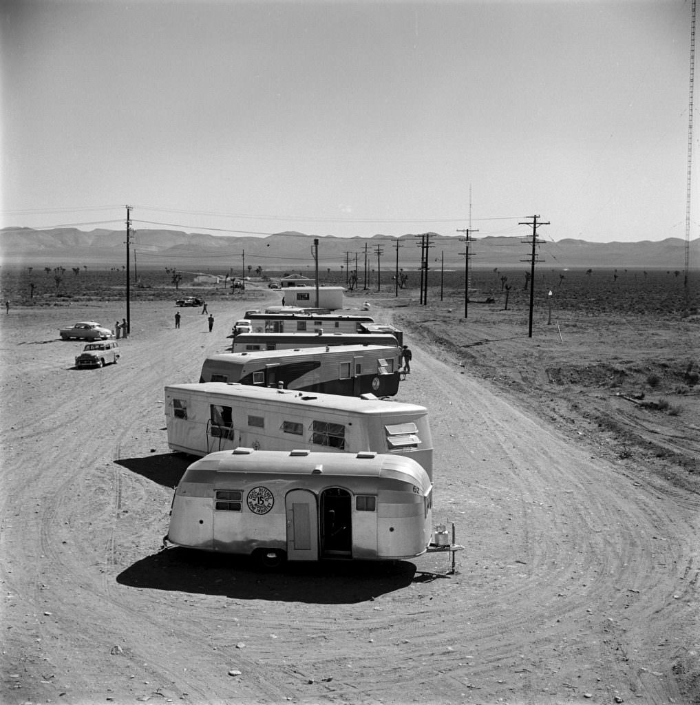 Vehicles lined up far from ground zero before a nuclear weapon test, Nevada, 1955.