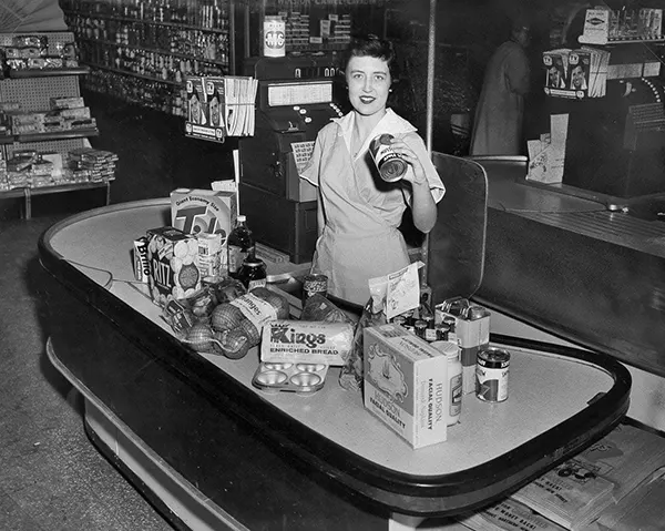 Cashier at the checkout of a grocery store, 1960.