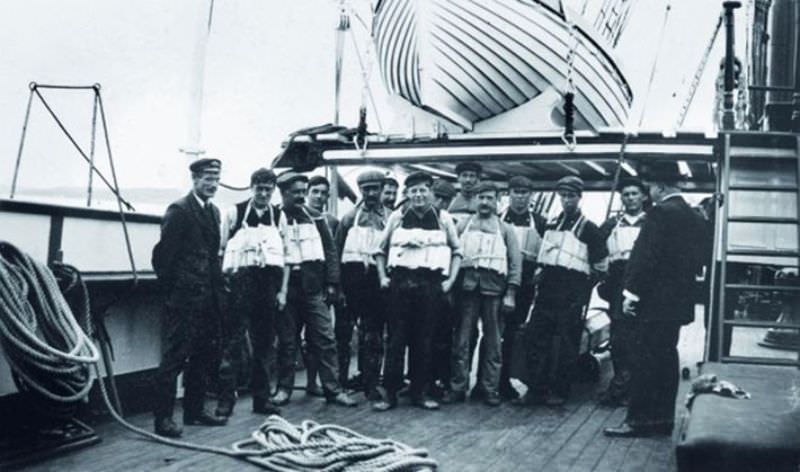 Members of the Titanic crew pose with lifejackets.