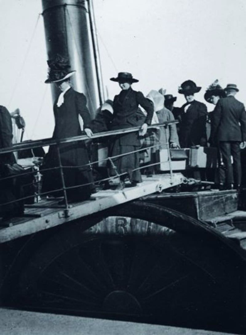 Ladies disembark from the tender “America” onto the Titanic.