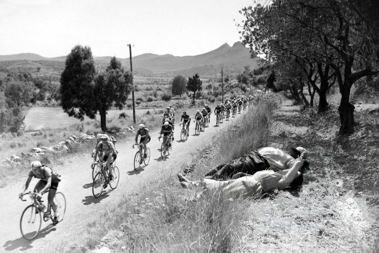 People asleep on the edge of the road during the Tour de France, 1953.