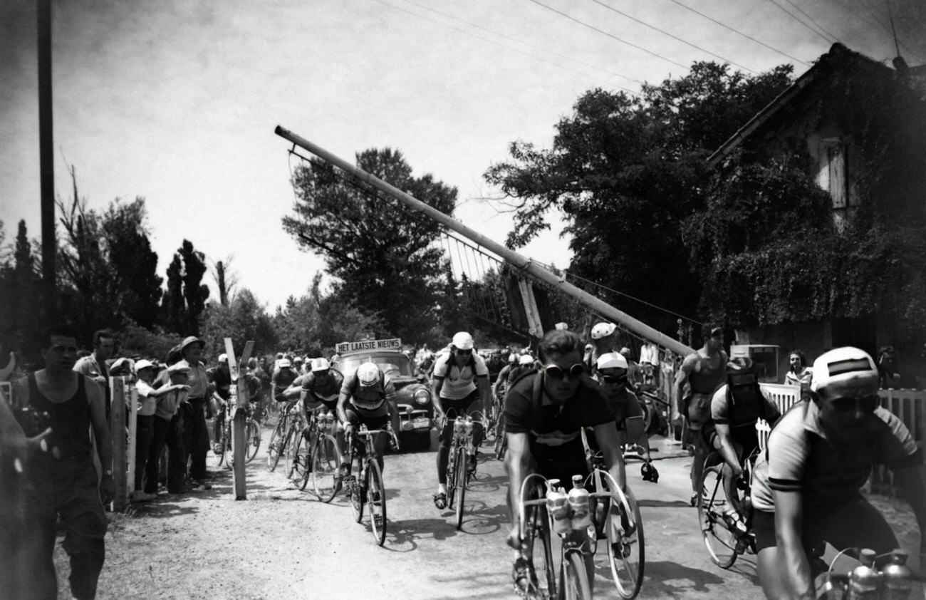 Cyclists at a grade crossing during the Tour de France, 1953.